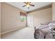 Neutral bedroom featuring a ceiling fan, window with valance, double closet and a cozy daybed at 13049 Thoroughbred Dr, Dade City, FL 33525