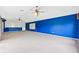 Spacious carpeted bonus room with blue accent wall and white projector screen at 13049 Thoroughbred Dr, Dade City, FL 33525