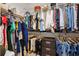 Organized walk-in closet with shelving and hanging storage solutions, containing an assortment of clothing and accessories at 13049 Thoroughbred Dr, Dade City, FL 33525