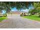 Spacious home featuring a long driveway, a two-car garage, and mature landscaping at 13049 Thoroughbred Dr, Dade City, FL 33525