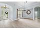 Elegant foyer featuring wood-look tile flooring, arched doorways, chandelier and natural light at 13049 Thoroughbred Dr, Dade City, FL 33525