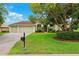Charming single Gathering home with a well-manicured lawn, mature landscaping, and a two car garage at 13049 Thoroughbred Dr, Dade City, FL 33525
