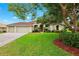 Charming single Gathering home with a well-manicured lawn, mature landscaping, and a two car garage at 13049 Thoroughbred Dr, Dade City, FL 33525