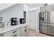 Bright kitchen with stainless steel fridge, gray cabinets, white countertops, and modern coffee maker at 13049 Thoroughbred Dr, Dade City, FL 33525