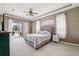 Cozy main bedroom featuring a tray ceiling, neutral walls, and sliding glass door to an outdoor patio at 13049 Thoroughbred Dr, Dade City, FL 33525