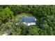 Single-story home surrounded by dense, green foliage at 3111 Arrowsmith Rd, Wimauma, FL 33598