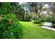 Landscaped backyard with lush greenery, white metal bench and a red mailbox at 3111 Arrowsmith Rd, Wimauma, FL 33598