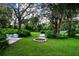 Landscaped backyard oasis with fire pit, seating, and hammock at 3111 Arrowsmith Rd, Wimauma, FL 33598