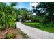 Gravel driveway leading to a house surrounded by tropical foliage at 3111 Arrowsmith Rd, Wimauma, FL 33598