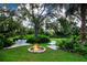 Landscaped backyard with a firepit and white metal furniture at 3111 Arrowsmith Rd, Wimauma, FL 33598