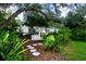 Charming house with a lush, landscaped front yard, featuring a white swing at 3111 Arrowsmith Rd, Wimauma, FL 33598