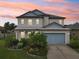 Two-story house with landscaped yard at sunset at 30425 Pecan Valley Loop, Wesley Chapel, FL 33543