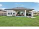 Backyard with covered patio, string lights and grassy area at 30425 Pecan Valley Loop, Wesley Chapel, FL 33543