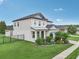 Two-story house with a light-blue garage door, landscaping, and a metal roof at 30425 Pecan Valley Loop, Wesley Chapel, FL 33543