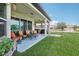 Relaxing covered patio with seating area, string lights, and a grassy backyard at 30425 Pecan Valley Loop, Wesley Chapel, FL 33543
