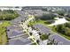 Aerial view of townhomes with a pond, lush landscaping, and ample parking, showcasing a tranquil community at 11638 Cambium Crown Dr, Riverview, FL 33569