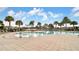 Beautiful community pool with inviting sun loungers surrounded by mature palm trees and a splash pad at 11638 Cambium Crown Dr, Riverview, FL 33569