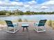 Two chairs and a table on a wooden deck with a serene view of the lake and trees at 11639 Sunshine Pond Rd, Tampa, FL 33635