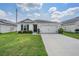 One-story home with attached garage and landscaped lawn at 7864 Broad Pointe Dr, Zephyrhills, FL 33540