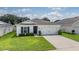House exterior with white siding, gray roof, and two-car garage at 7864 Broad Pointe Dr, Zephyrhills, FL 33540