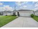 House exterior with white siding, gray roof, and two-car garage at 7864 Broad Pointe Dr, Zephyrhills, FL 33540