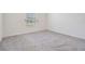 Simple bedroom with grey carpet and a window with blinds at 7864 Broad Pointe Dr, Zephyrhills, FL 33540