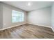 Bright bedroom with large window and wood-look floors at 11923 Downy Birch Dr, Riverview, FL 33569