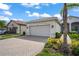 House exterior with two-car garage and landscaping at 4906 Avila Lakes Dr, Wimauma, FL 33598