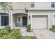 Townhouse exterior featuring a gray facade, a double garage, and landscaping at 7010 Summer Holly Pl, Riverview, FL 33578