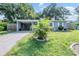 Lovely one-story home featuring a covered car port and a small palm tree in the front yard at 1611 Stevenson Dr, Clearwater, FL 33755