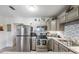 Well-lit kitchen featuring stainless steel appliances, granite counters and tile backsplash at 1611 Stevenson Dr, Clearwater, FL 33755