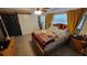 Cozy bedroom features a decorative quilt, wood frame bed, natural light, and an ensuite bathroom for added privacy at 8013 N Ola Ave, Tampa, FL 33604