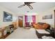 Living room with orange couch, recliner, and ceiling fan at 1240 Chelsea Ln, Holiday, FL 34691