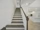 Elegant staircase with dark wood treads, white risers, and a decorative wood railing at 33857 Landsman Loop, Wesley Chapel, FL 33543