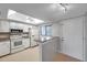 Well-lit kitchen with white cabinets and granite countertops at 2440 Winding Creek Blvd # 201, Clearwater, FL 33761