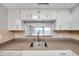 Kitchen features granite countertops, stainless steel sink, and white cabinets at 2440 Winding Creek Blvd # 201, Clearwater, FL 33761