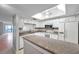 Modern kitchen featuring white cabinets and a granite island at 2440 Winding Creek Blvd # 201, Clearwater, FL 33761