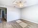 Bedroom with ceiling fan, wood-look floors, and access to hallway at 9083 Quail Creek Dr, Tampa, FL 33647