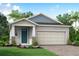 One-story house with teal door and light gray siding at 5714 Spivey Ct, Wesley Chapel, FL 33545