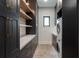 Bright laundry room, featuring dark cabinetry, quartz countertops, and brick-patterned flooring at 3305 W Beaumont St, Tampa, FL 33611