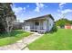 Cozy single-story home with a side porch, surrounded by a well-manicured lawn on a sunny day at 14620 Coral Dr, Hudson, FL 34667
