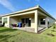 Well-maintained house exterior with a covered patio and lush lawn at 32676 Tree Of Life Ave, Wesley Chapel, FL 33543