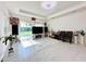 Spacious living room with large TV, sliding glass doors, and tile flooring at 32676 Tree Of Life Ave, Wesley Chapel, FL 33543