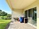 Covered patio with brick pavers, grill, and access to backyard at 32676 Tree Of Life Ave, Wesley Chapel, FL 33543