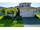 Two-story house with a two-car garage and landscaped yard at 32676 Tree Of Life Ave, Wesley Chapel, FL 33543