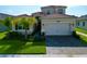 Two-story house with a beige exterior and a brick paver driveway at 32676 Tree Of Life Ave, Wesley Chapel, FL 33543