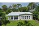 Tan ranch-style home with a metal roof, covered porch, and large windows at 20605 Preston Ln, Lutz, FL 33558