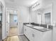 Double sink bathroom with dark countertop and white cabinets at 5472 Summer Sunset Dr, Apollo Beach, FL 33572