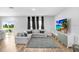 Living room features grey sectional sofa and backyard access at 5472 Summer Sunset Dr, Apollo Beach, FL 33572