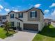 Two-story house with teal door, gray garage door, and landscaping at 31417 Sun Kettle Loop, Wesley Chapel, FL 33545